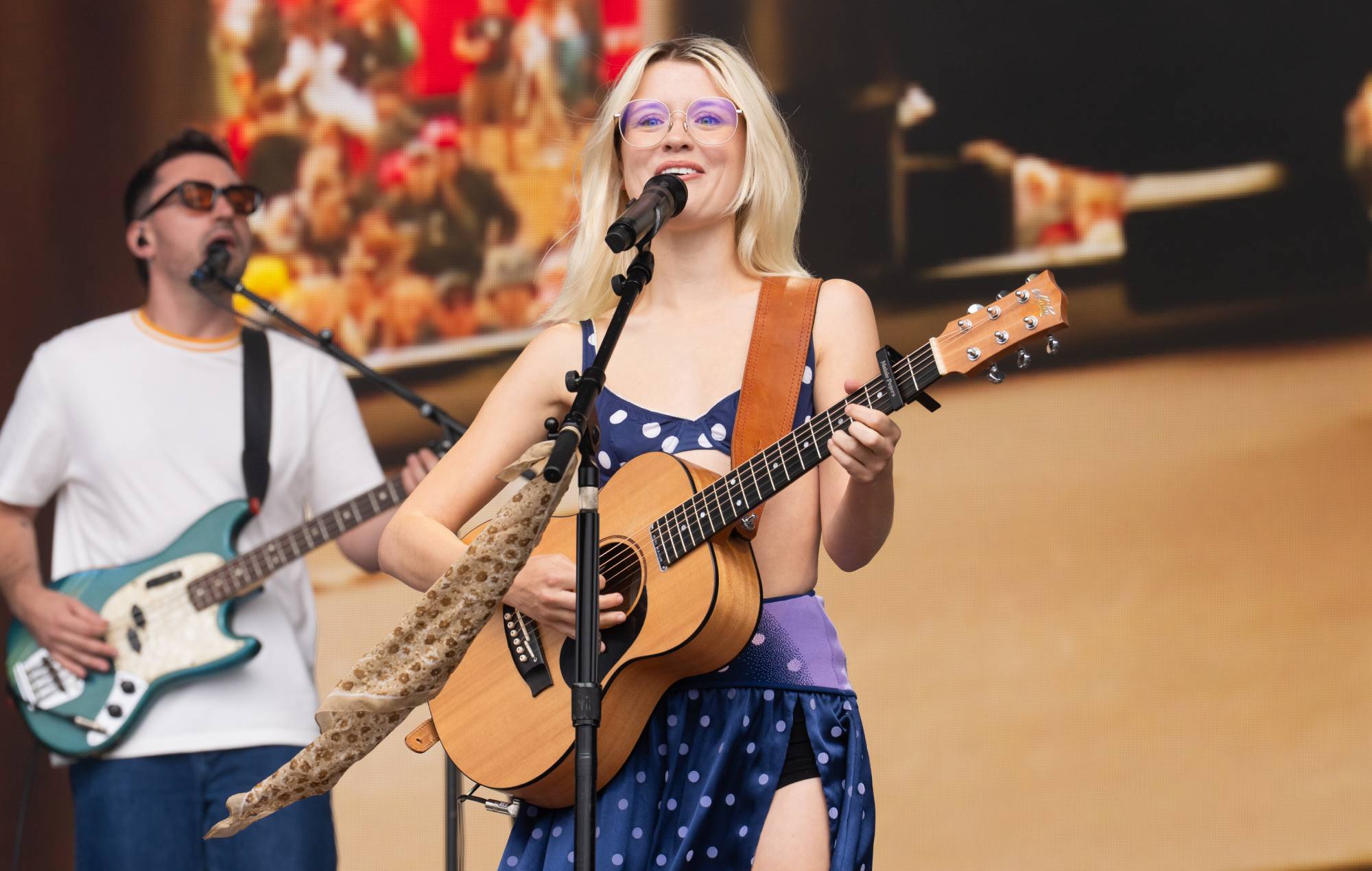 Maisie Peters performing on stage during a music festival set