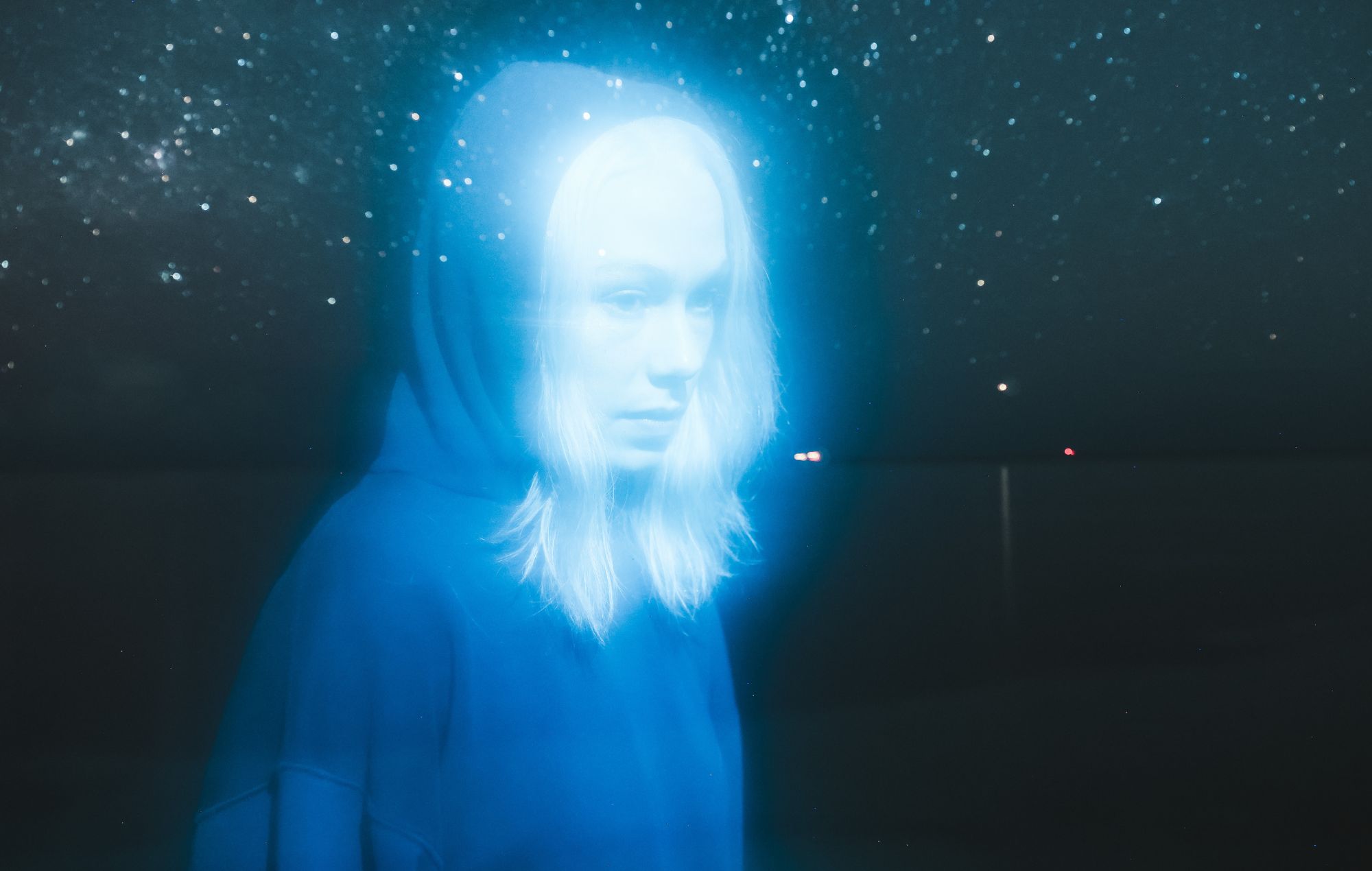 Phoebe Bridgers performing live on stage with a guitar
