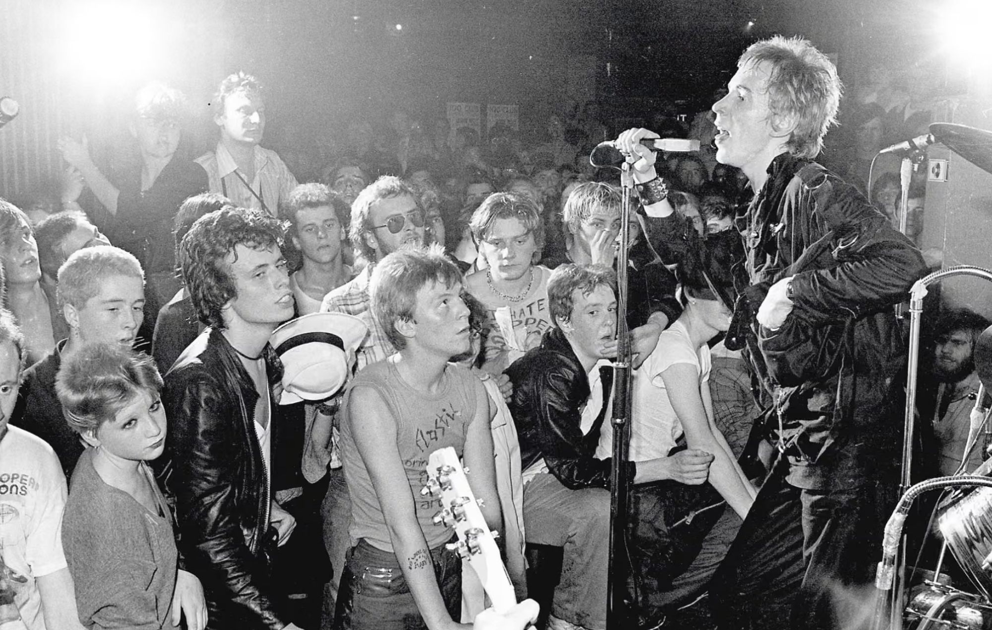 Sprints performing live on stage in front of an energetic crowd at an underground music venue