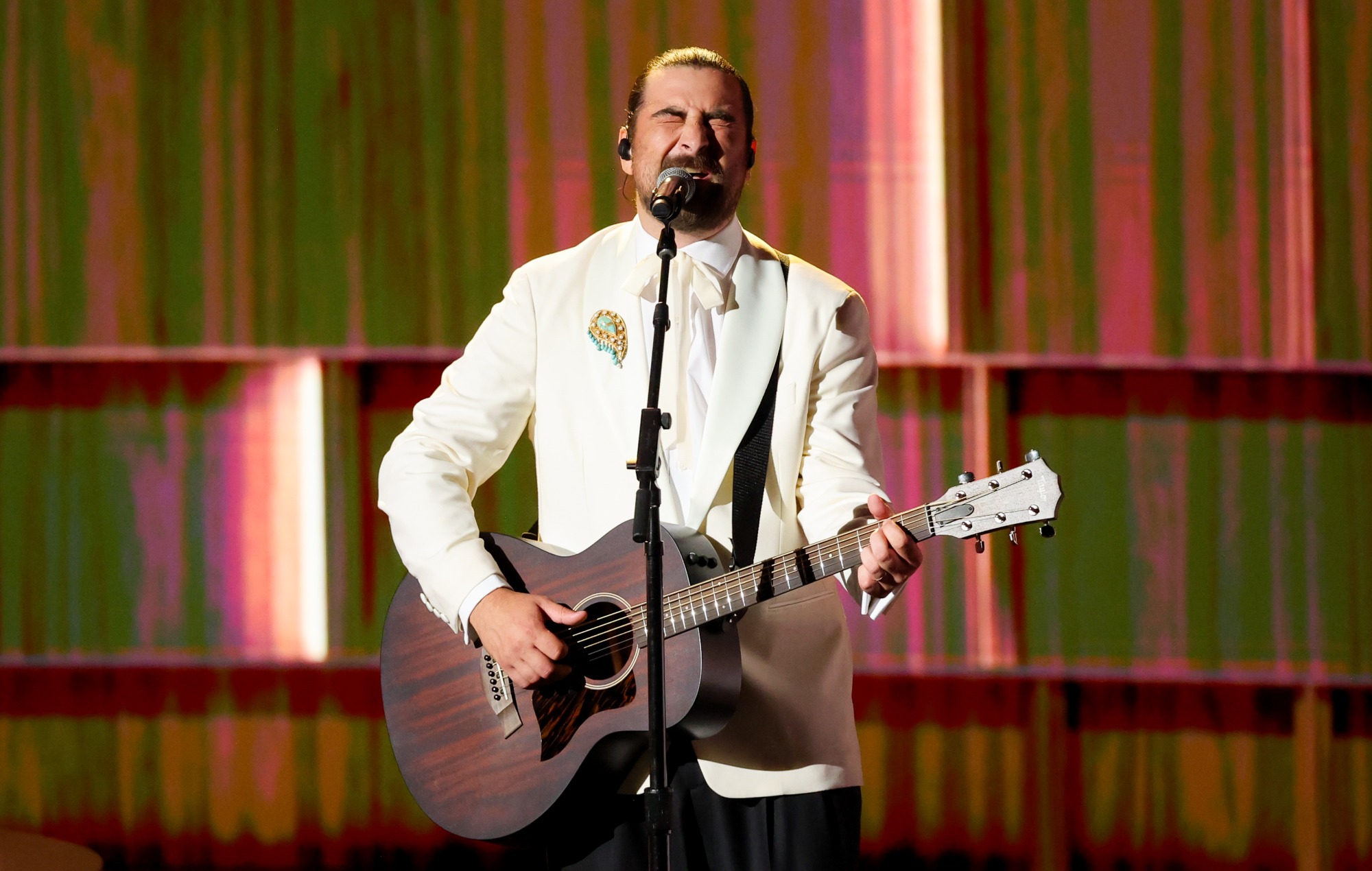 Noah Kahan playing guitar on stage during the Emmys In Memoriam performance