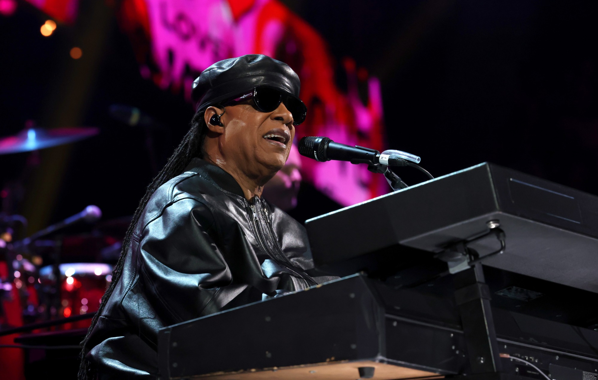 Stevie Wonder smiling on stage during a concert performance