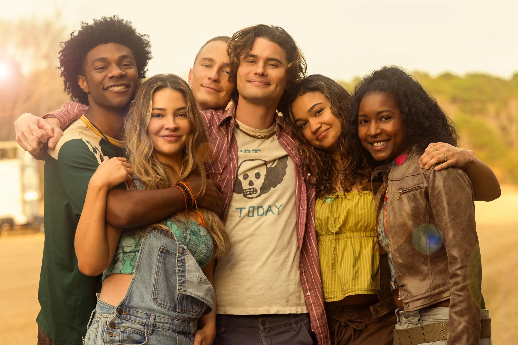 Cast members of Outer Banks posing outdoors in beachwear