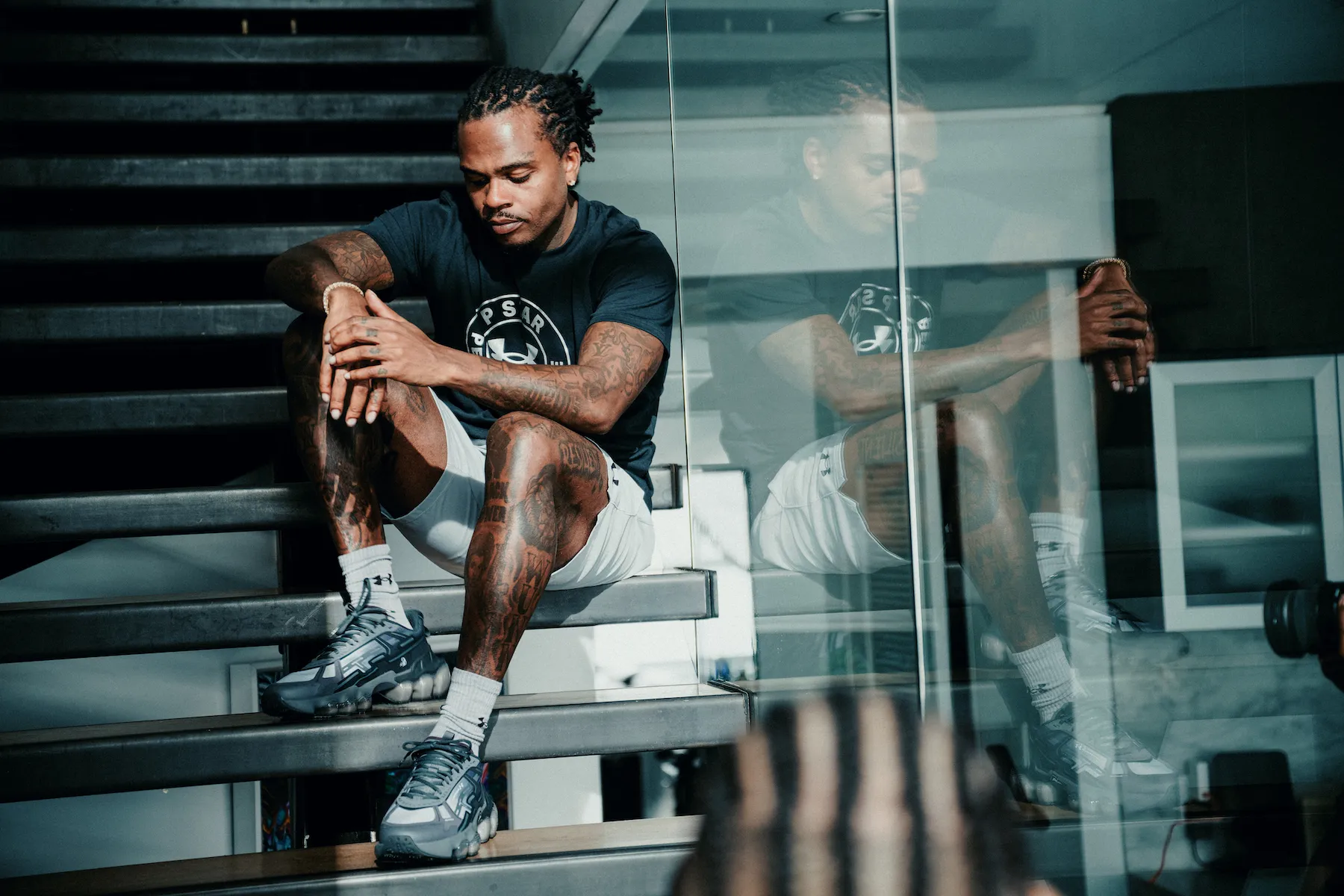 Gunna posing in activewear while listening to music in the gym