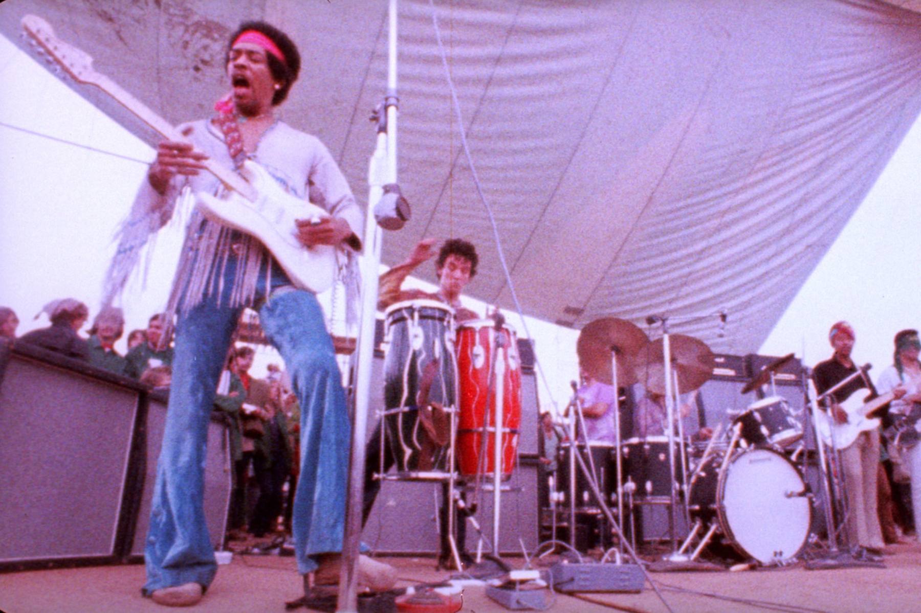 Jimi Hendrix performing on stage with his guitar
