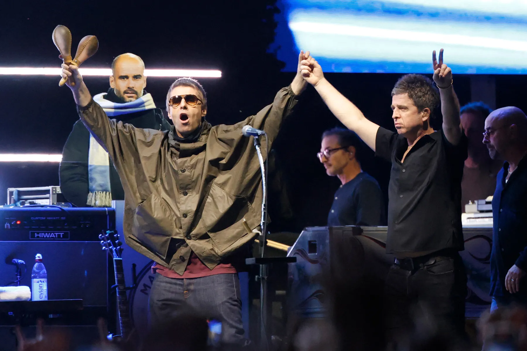 Noel Gallagher performing on stage with Oasis