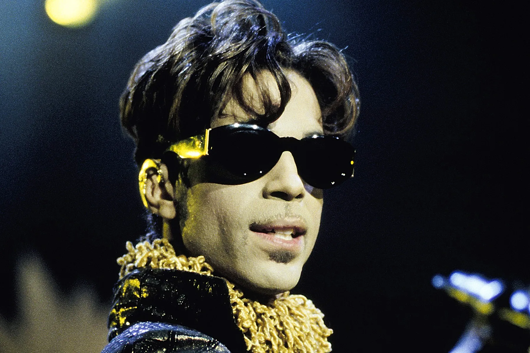 Prince performing live on stage during a concert performance.