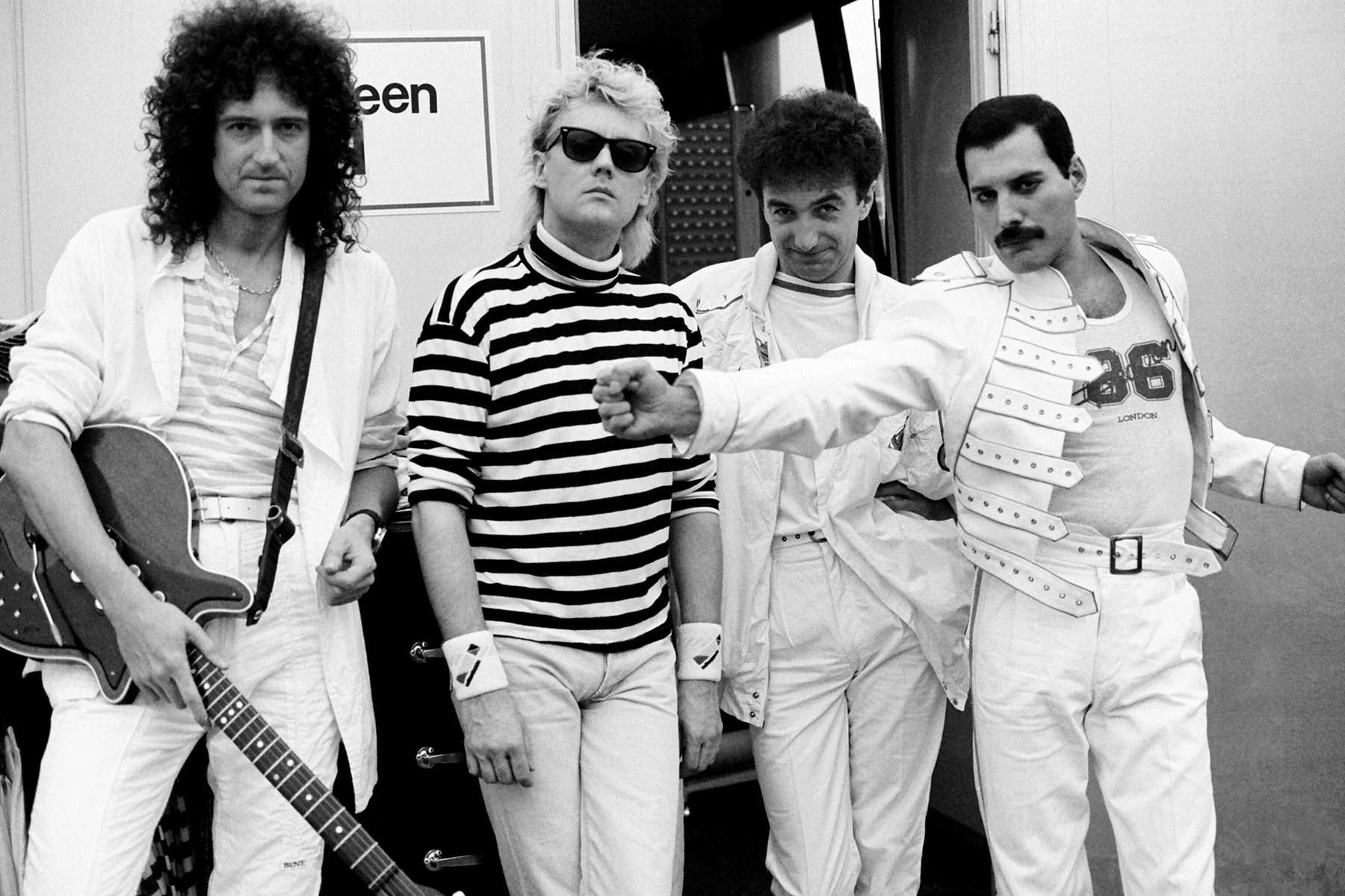 Freddie Mercury performing on stage with Queen during a stadium concert