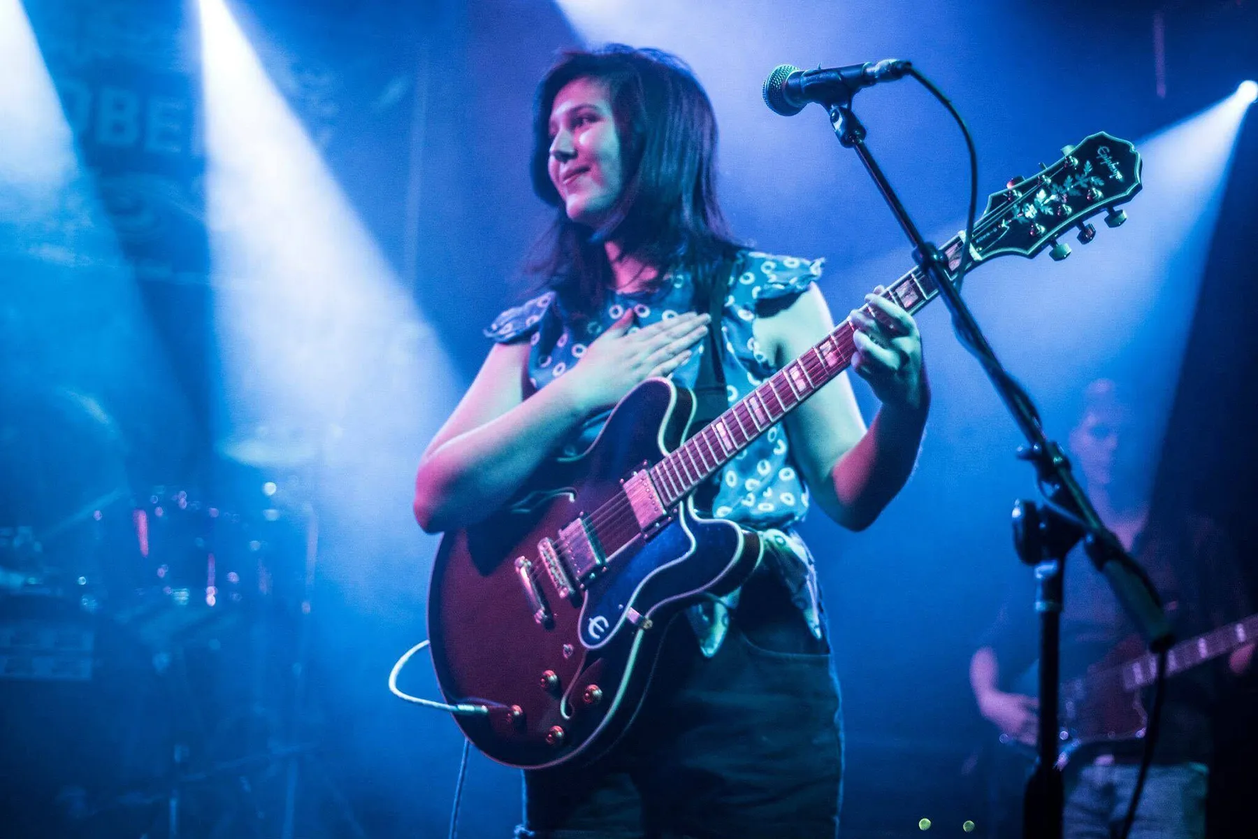 Lucy Dacus performing on stage with an electric guitar