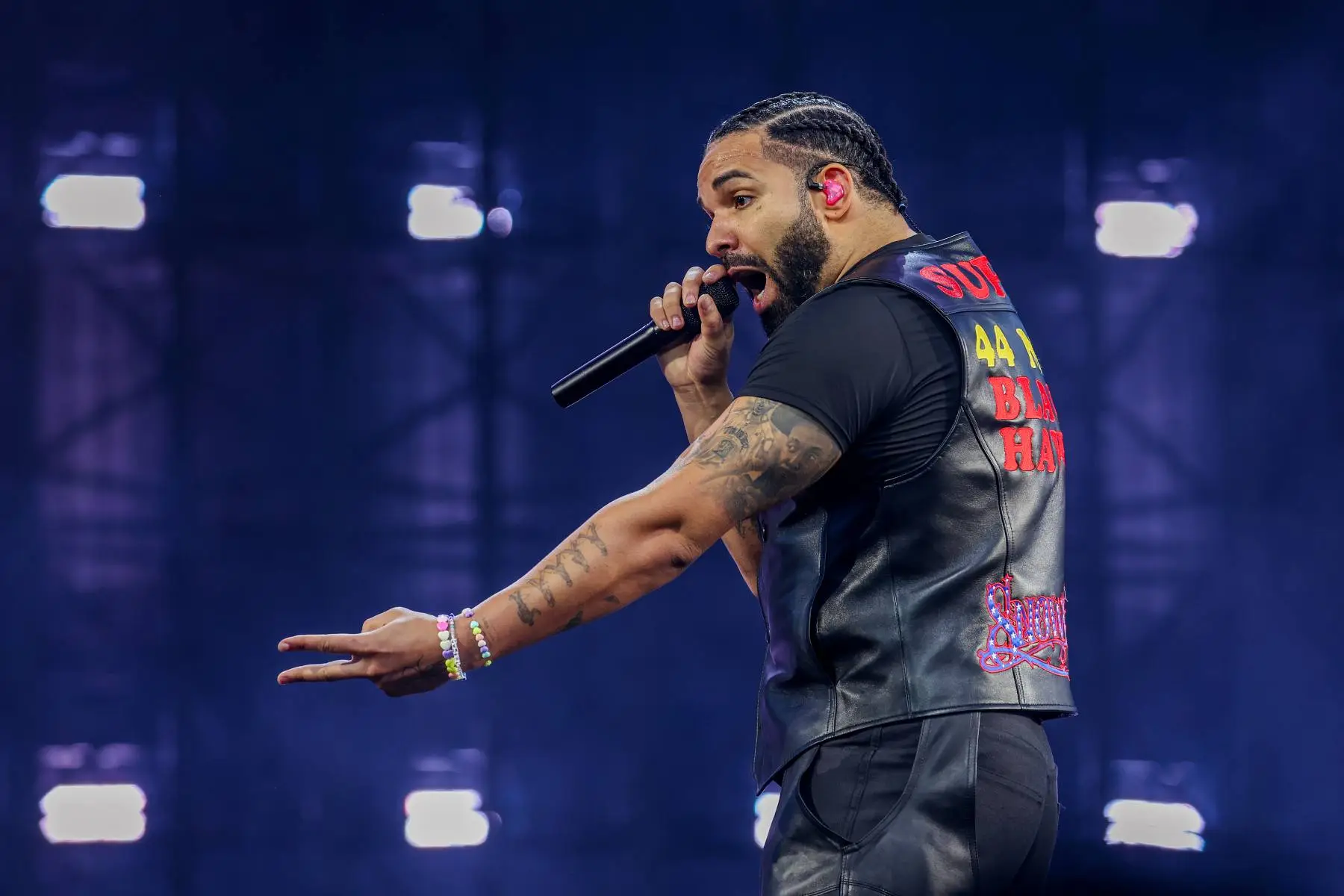Drake performing live on stage under spotlights
