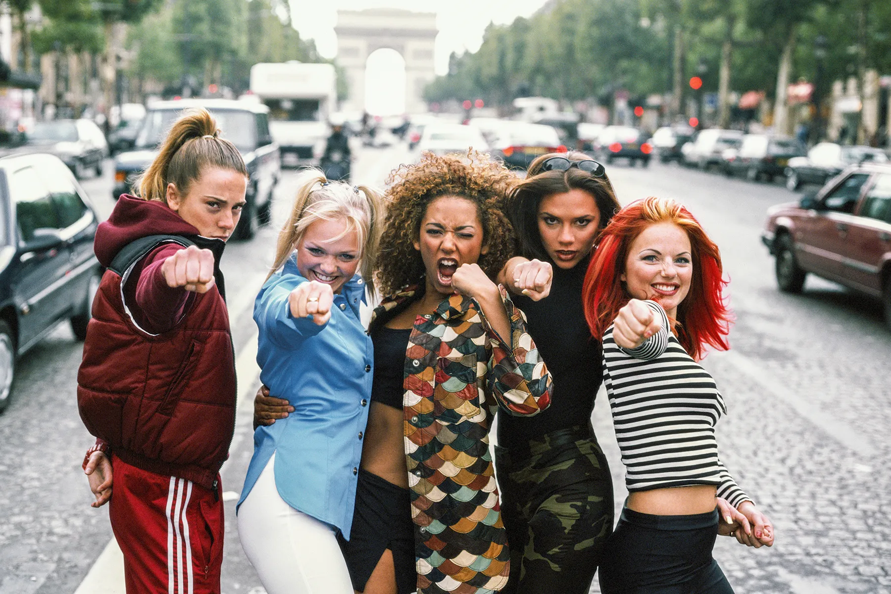 The Spice Girls posing together on stage during a concert performance
