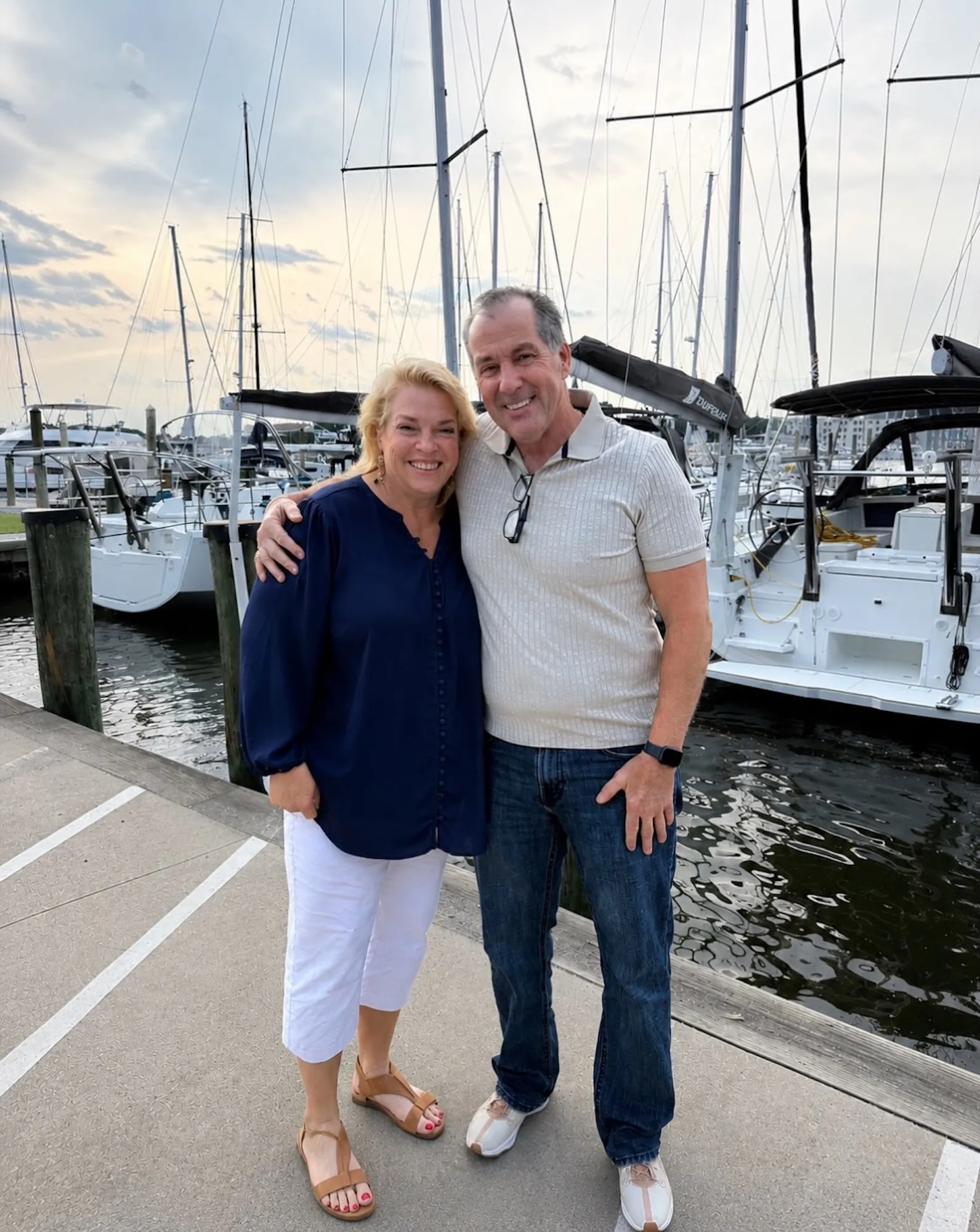Janelle Brown smiling next to her new boyfriend Pete on a dock surrounded by boats