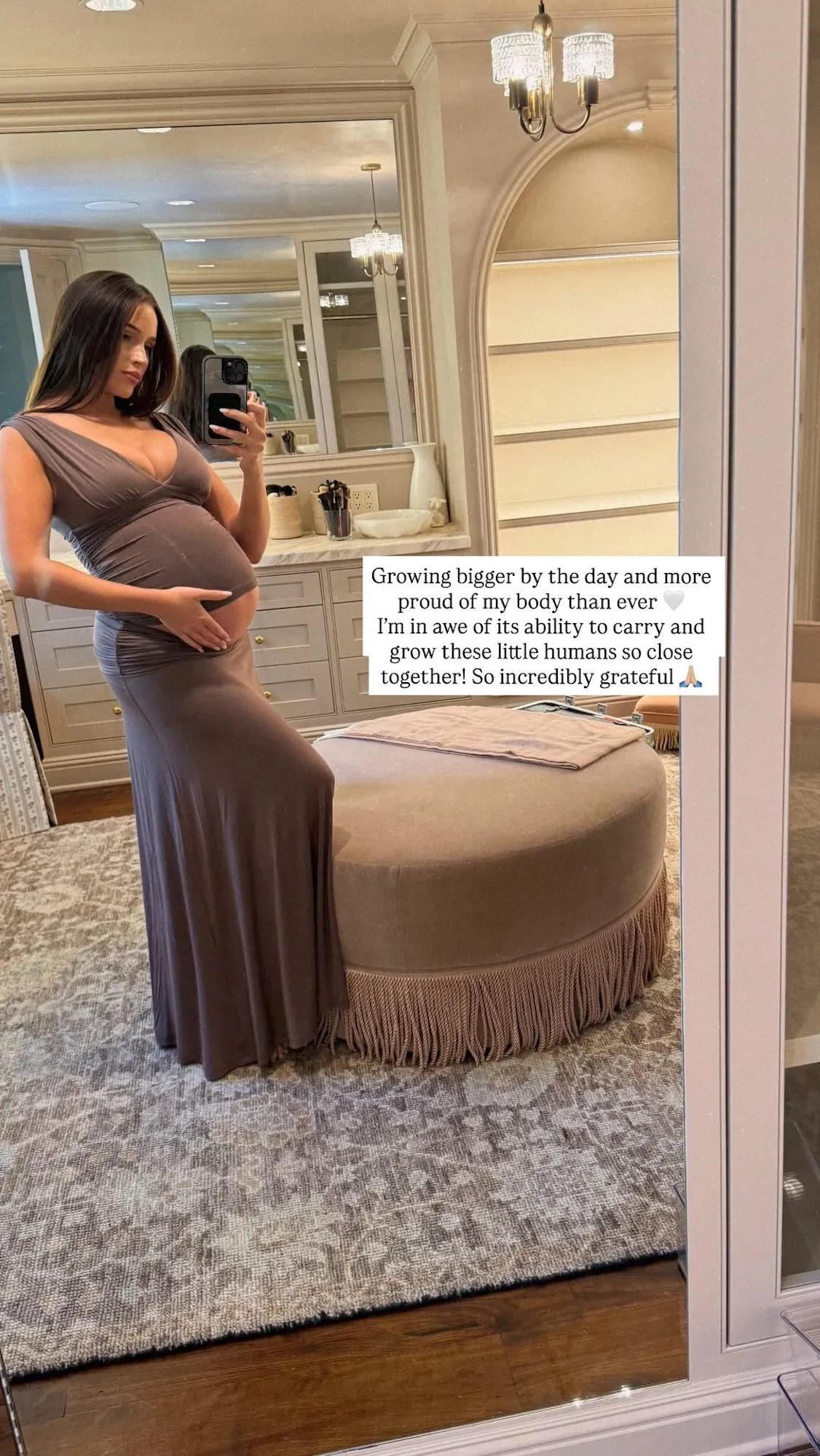 Olivia Culpo posing in a brown outfit while cradling her pregnant belly
