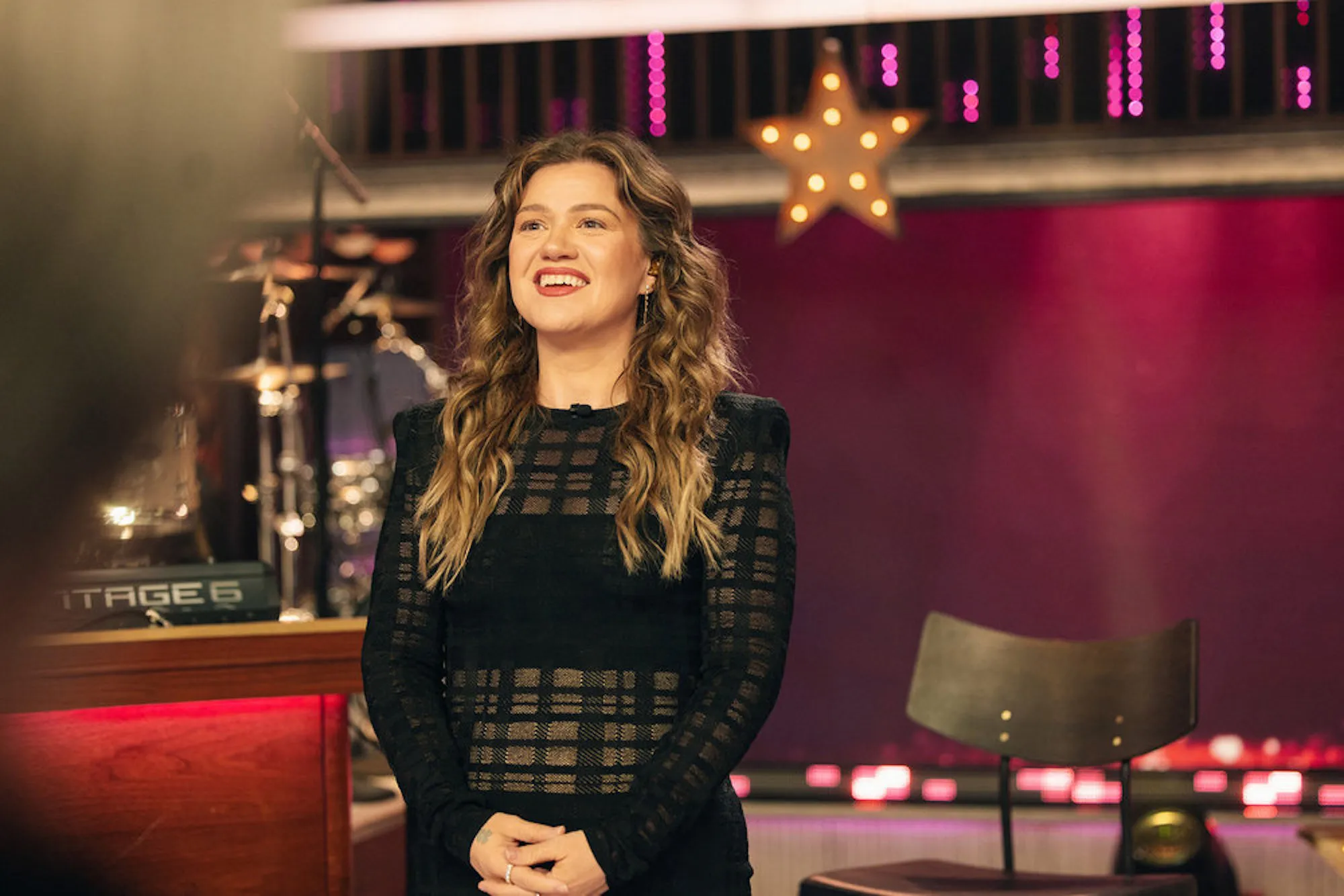 Kelly Clarkson smiling on the set of her daytime talk show