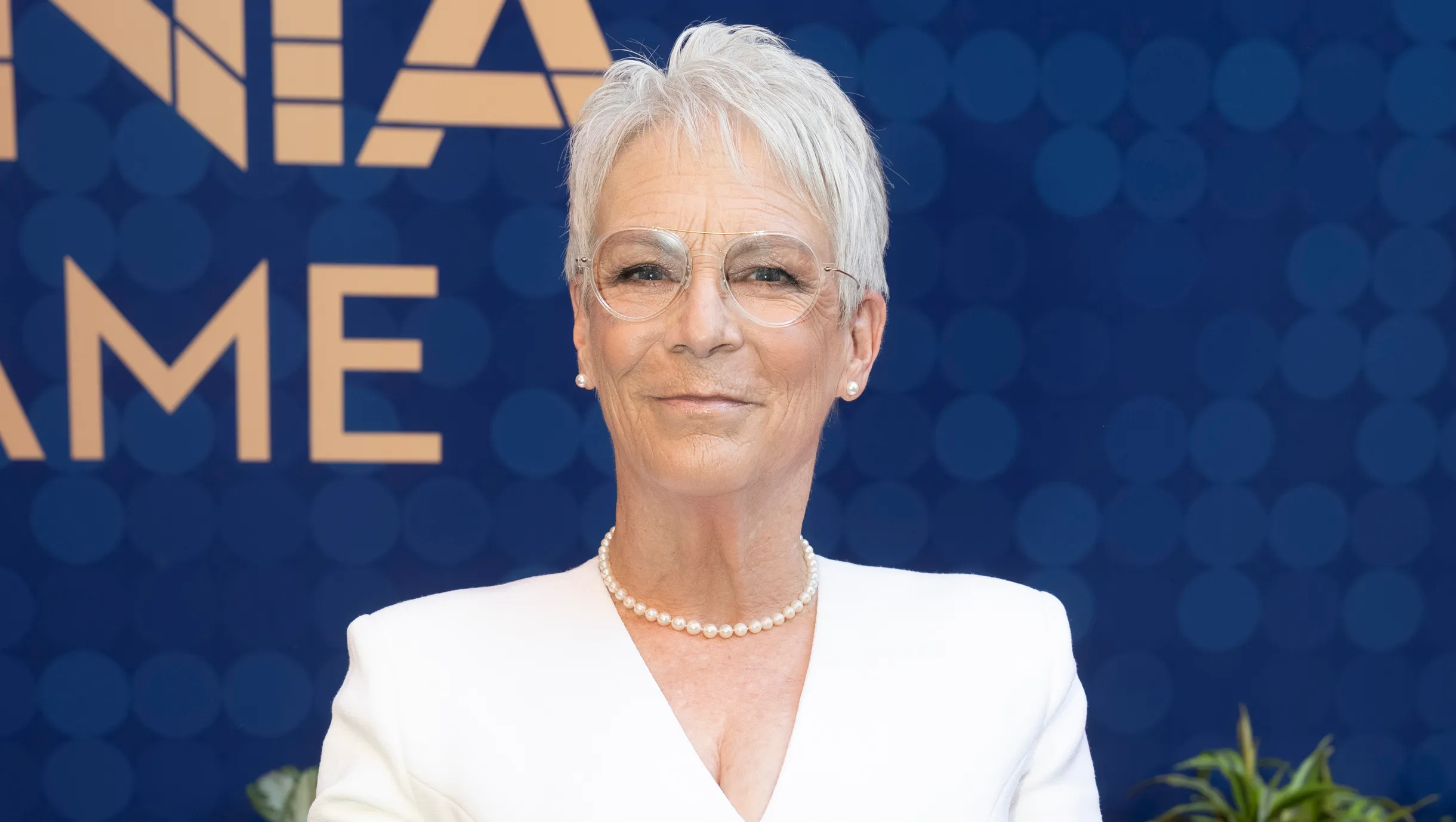 Jamie Lee Curtis smiling on the red carpet at a movie premiere