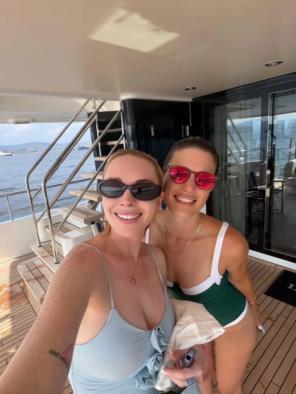 Lindsay Lohan lounging in a pale blue swimsuit during a family yacht trip