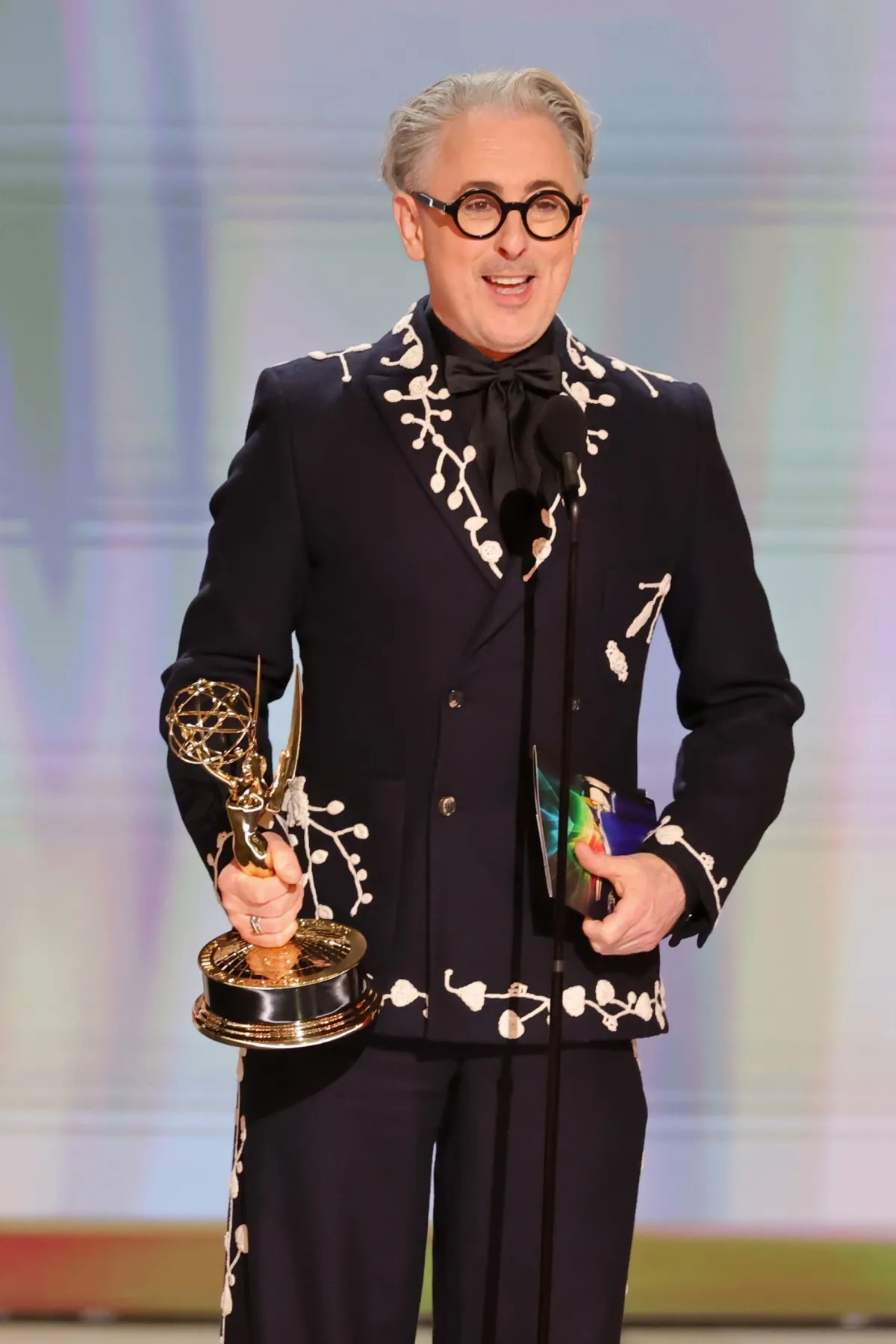 Alan Cumming accepting an Emmy Award for The Traitors on stage at the Peacock Theater