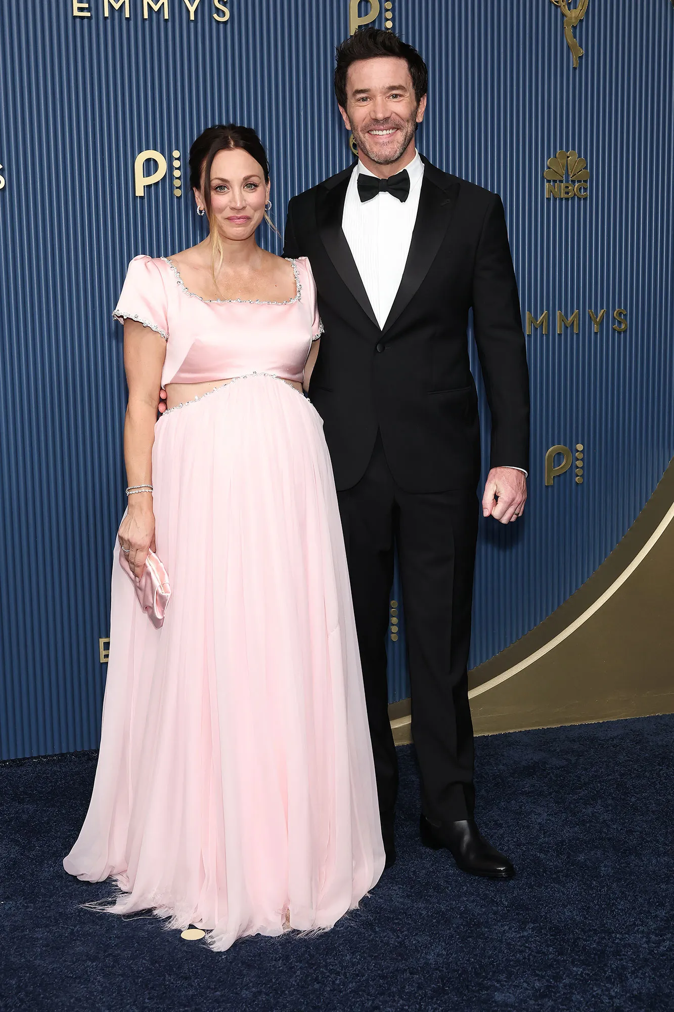 Kaley Cuoco and Tom Pelphrey pose together on the 2026 Emmy Awards red carpet in Los Angeles