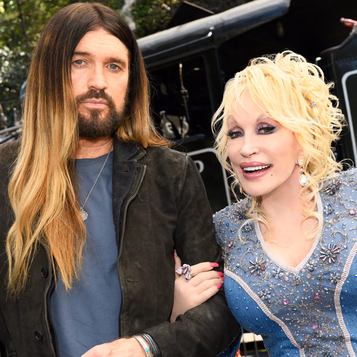 Billy Ray Cyrus and Dolly Parton posing together at a country music event
