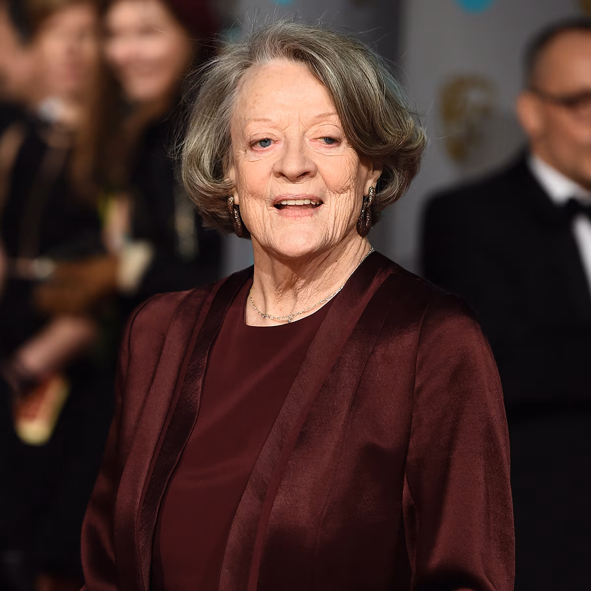 Maggie Smith smiling on a red carpet