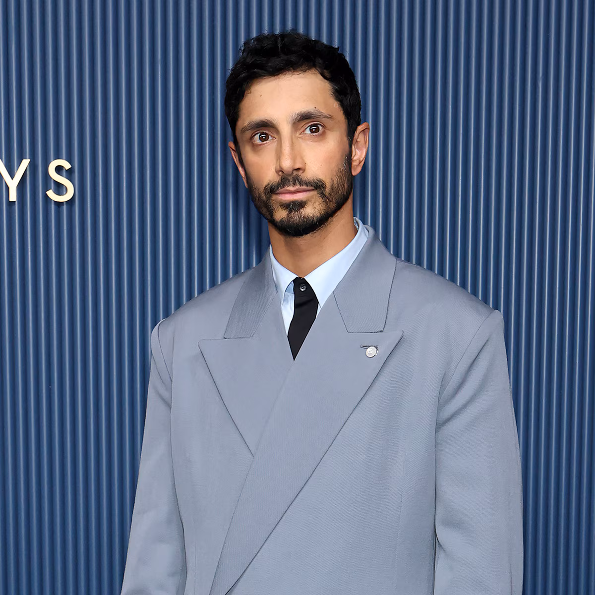 Riz Ahmed smiling on a red carpet