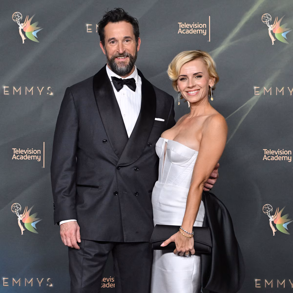 Noah Wyle and wife Sara Wells posing together on the red carpet at an awards event.