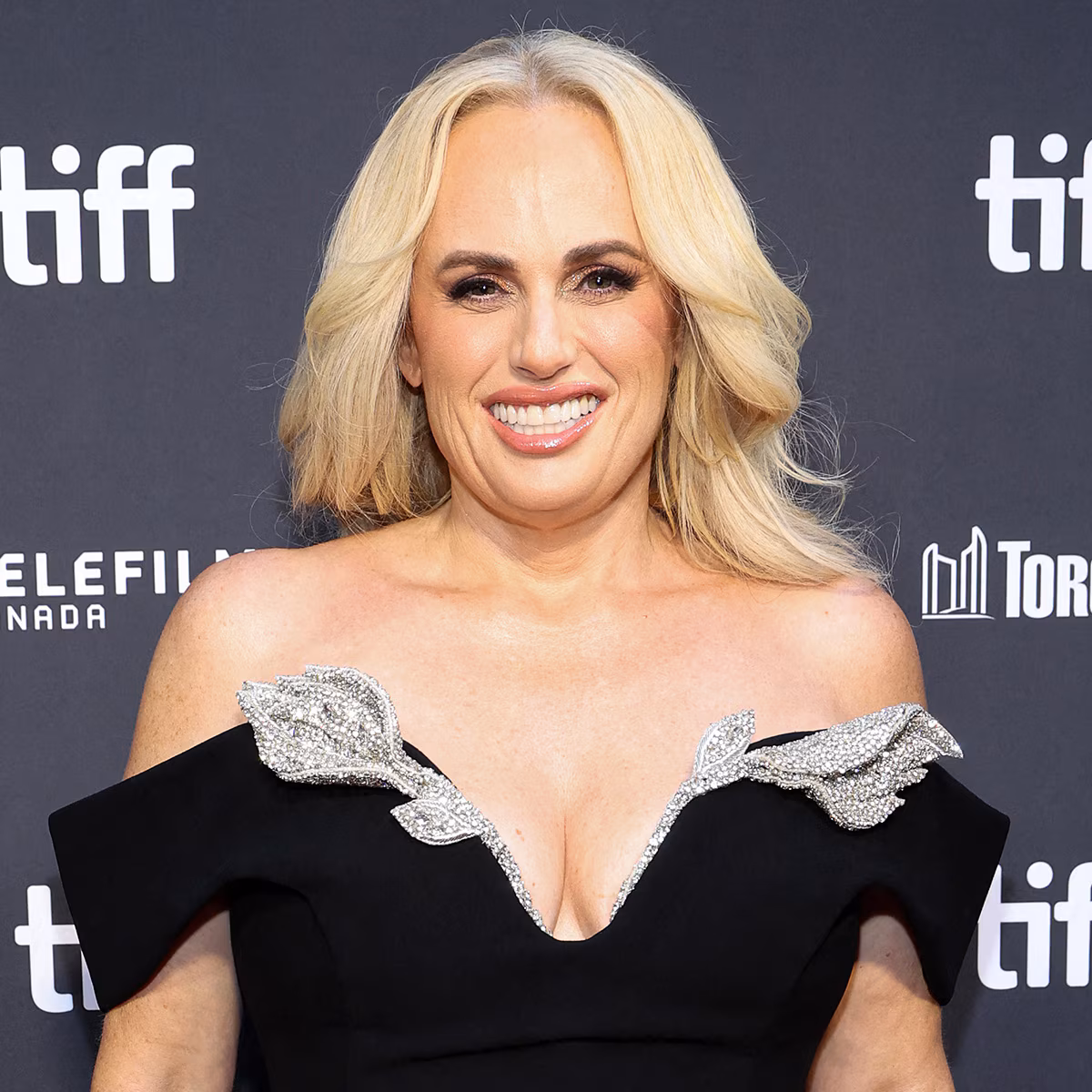 Rebel Wilson smiling on a red carpet