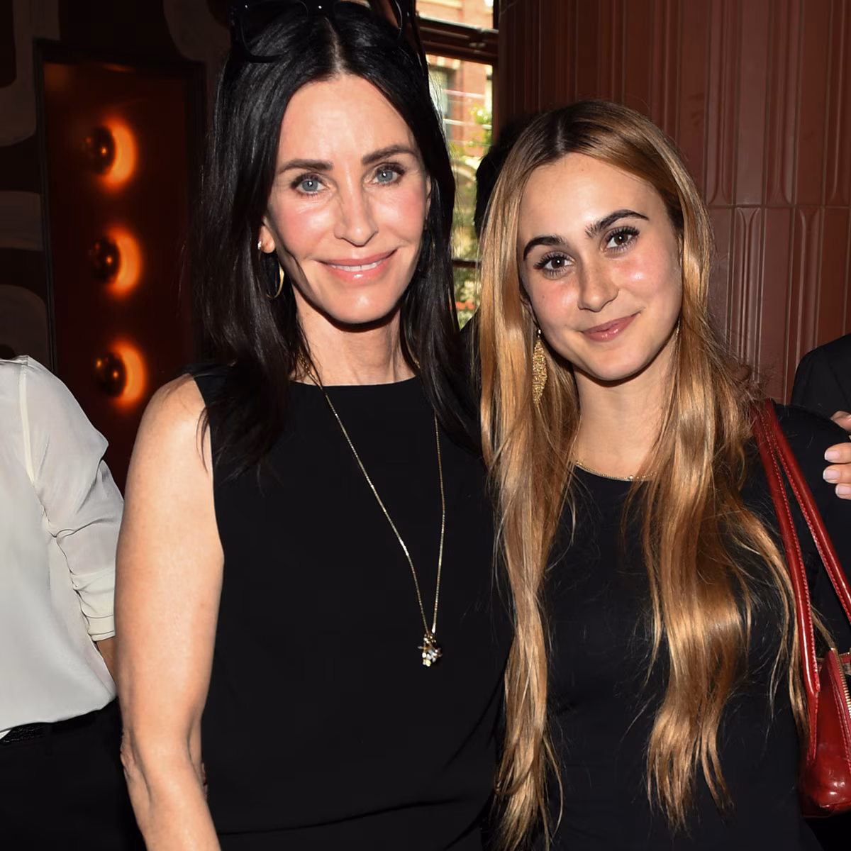 Courteney Cox smiling at a movie premiere event