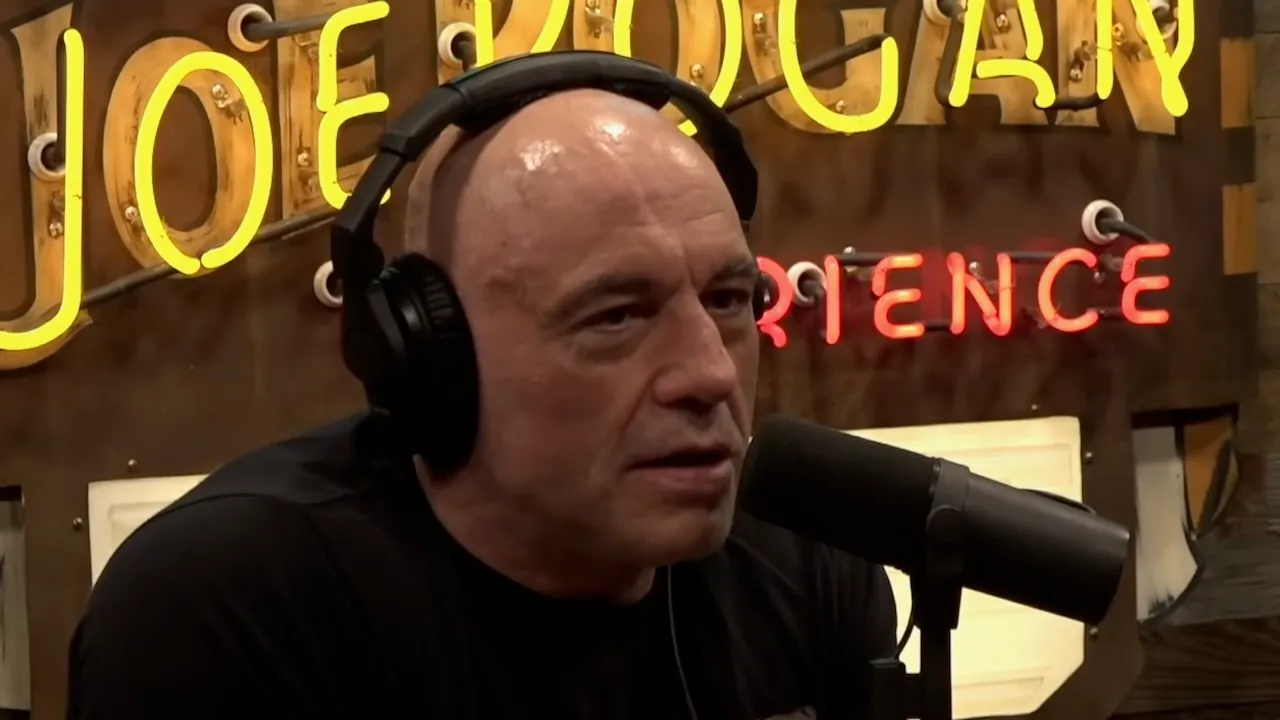 Joe Rogan talking into a studio microphone during a podcast recording