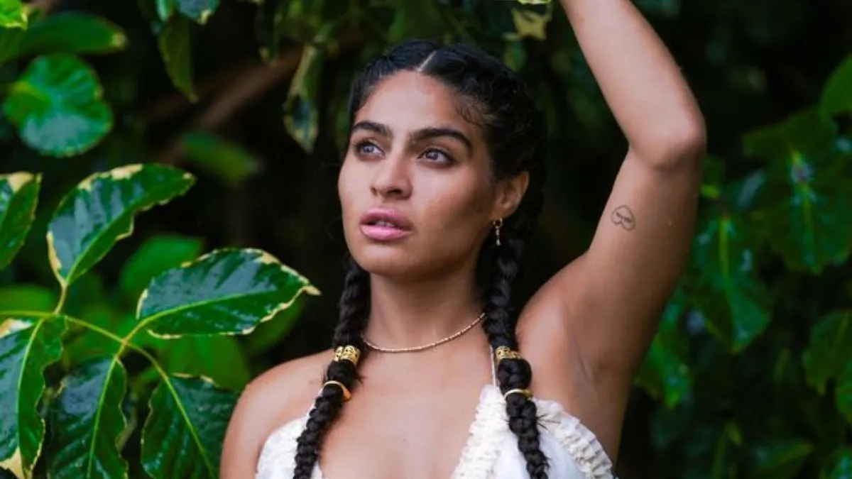 Jessie Reyez performing live on stage in front of a concert crowd