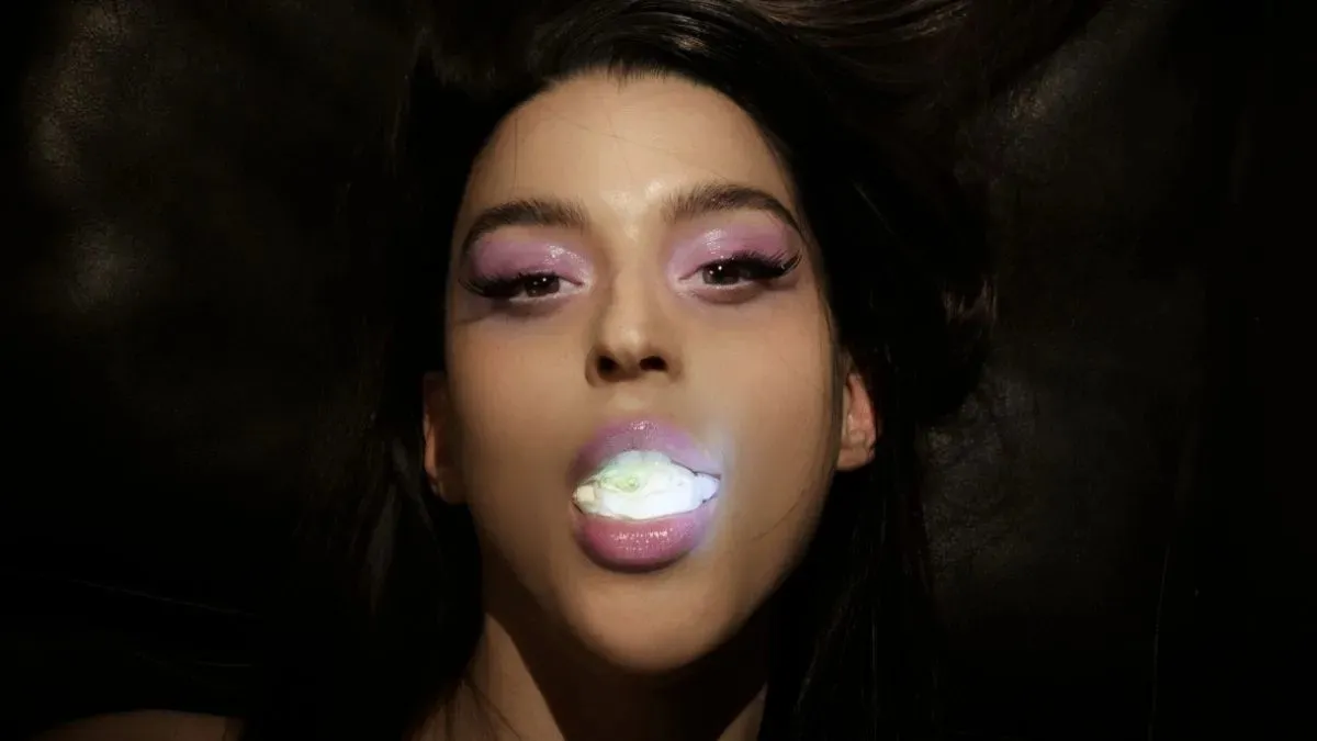 Arca performing live on stage under concert lights
