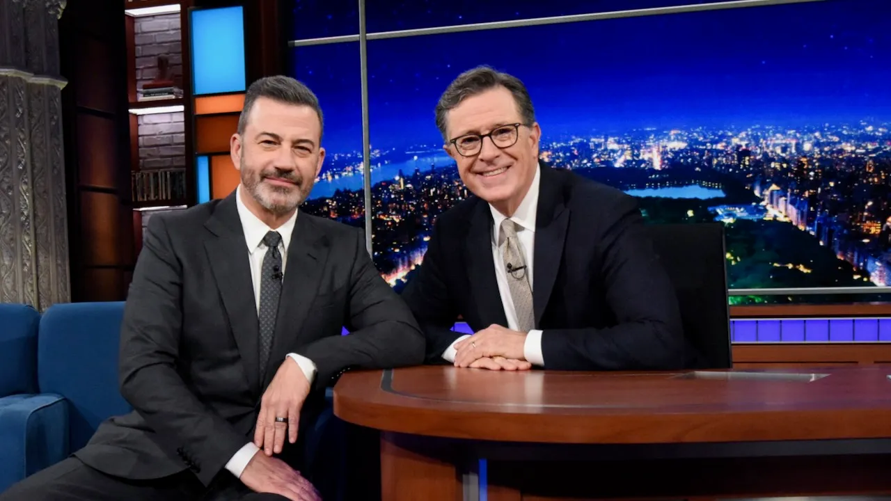 Stephen Colbert smiling on stage at a late-night television event