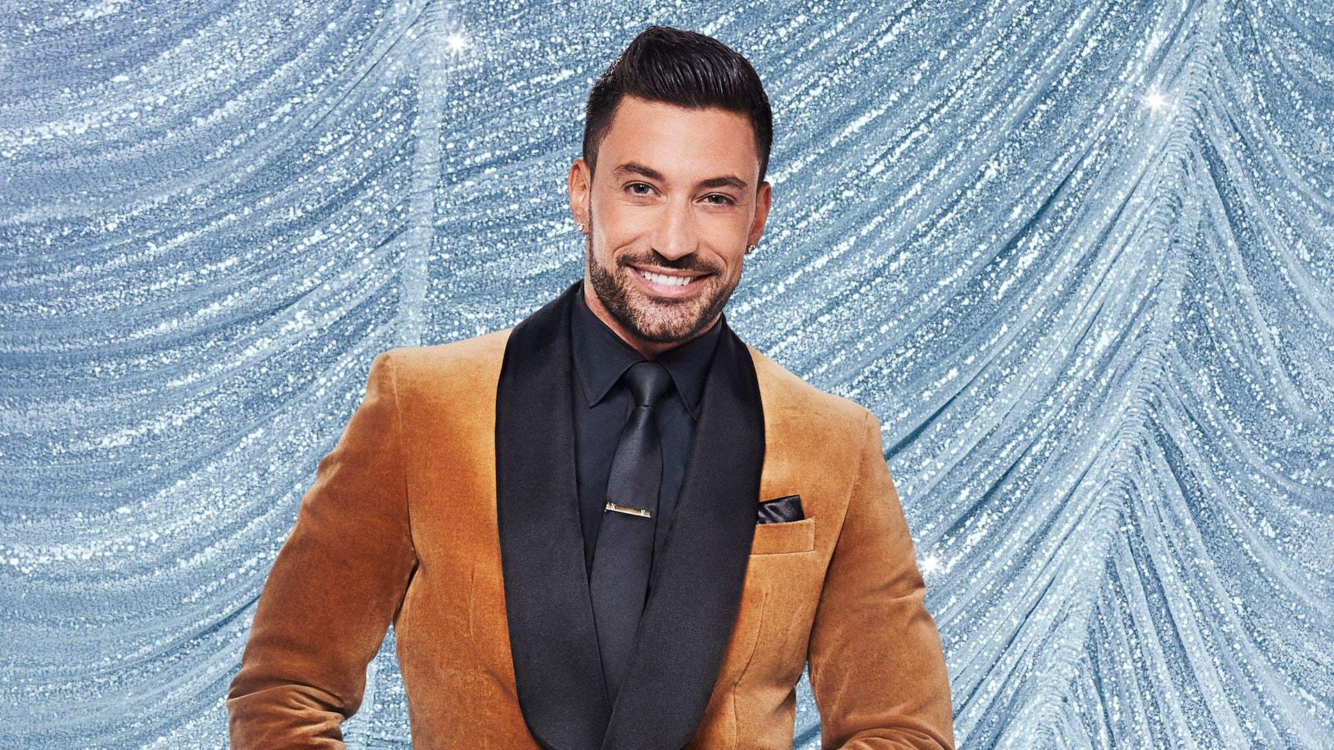 Giovanni Pernice posing on a red carpet in a formal suit
