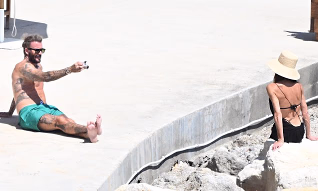 David Beckham taking photos of Victoria Beckham on a boat near the Amalfi coast in Italy.