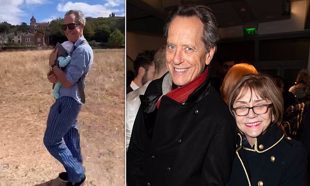 Richard E. Grant smiling on a red carpet event