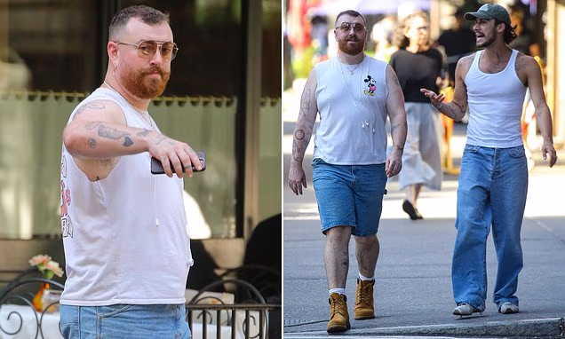 Sam Smith and fiancé Christian Cowan walking in New York City wearing matching white tank tops.