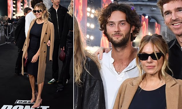 Sienna Miller and Oli Green posing together on a red carpet at a London movie premiere.