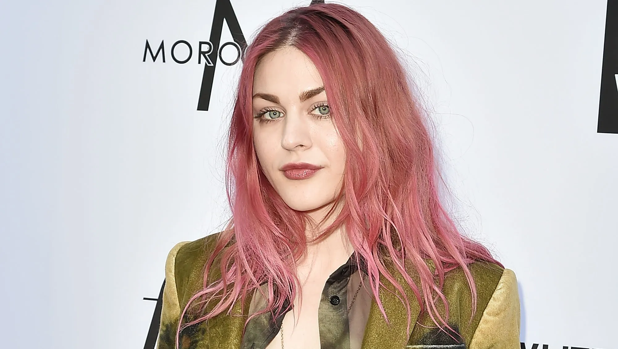 Frances Bean Cobain posing at a fashion event in a stylish dark outfit