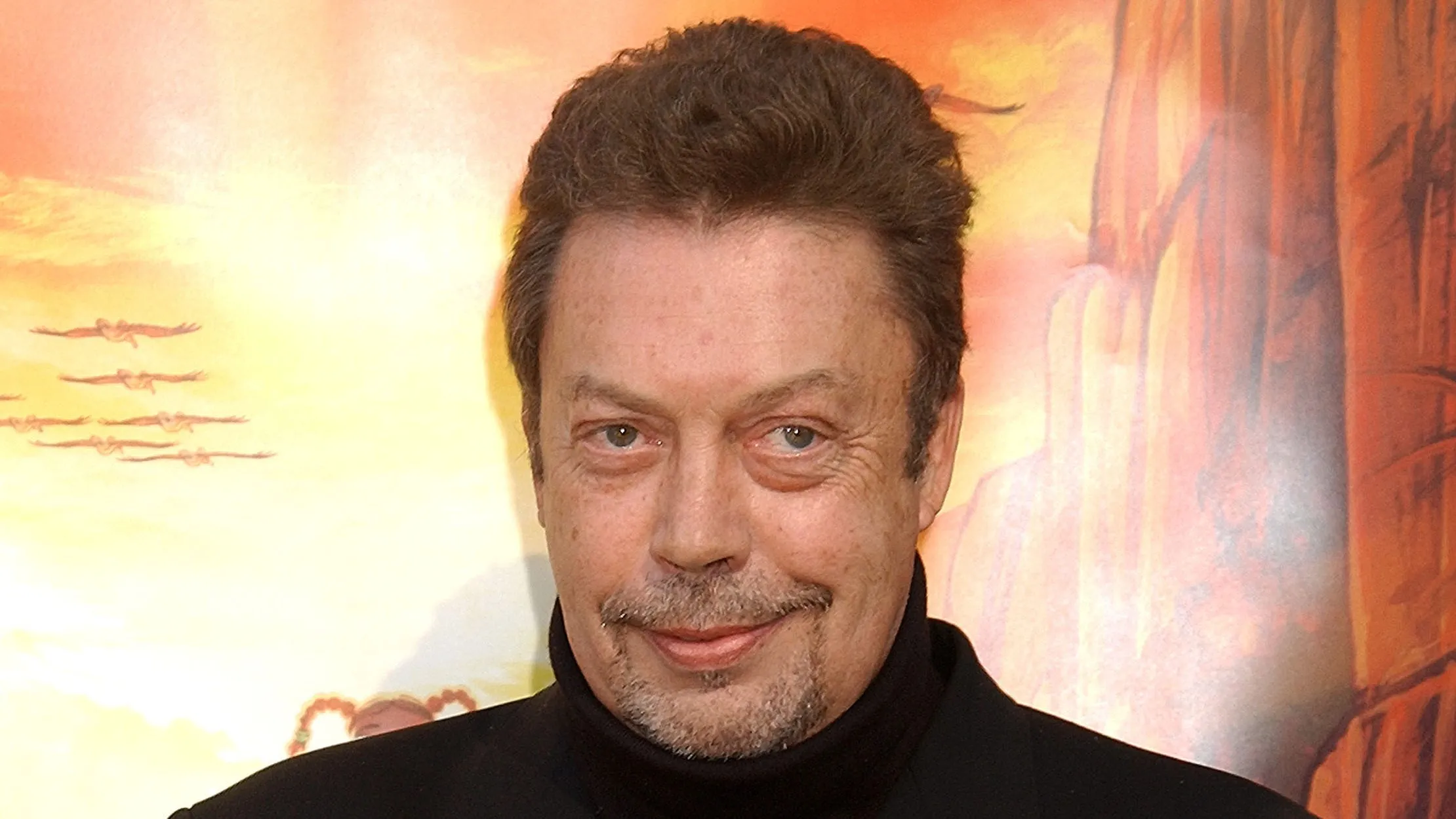 Actor Tim Curry posing on a red carpet