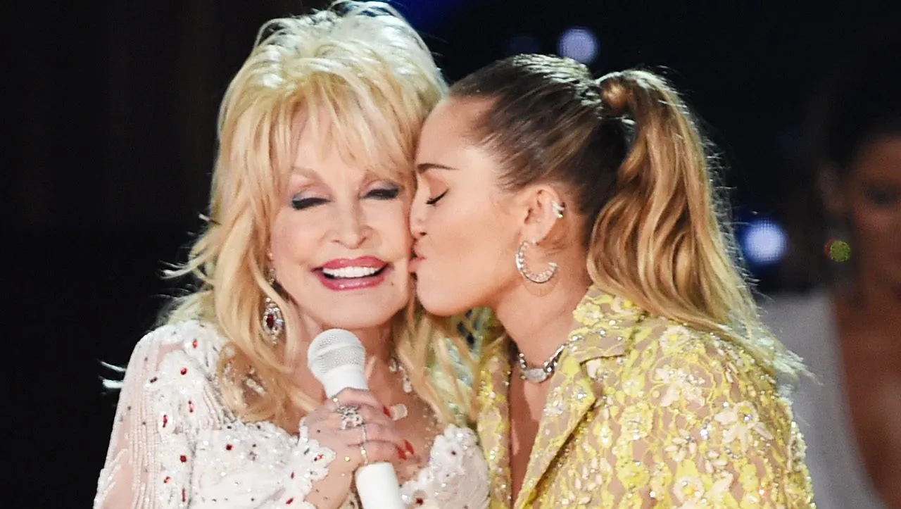 Miley Cyrus and Dolly Parton posing together at an event