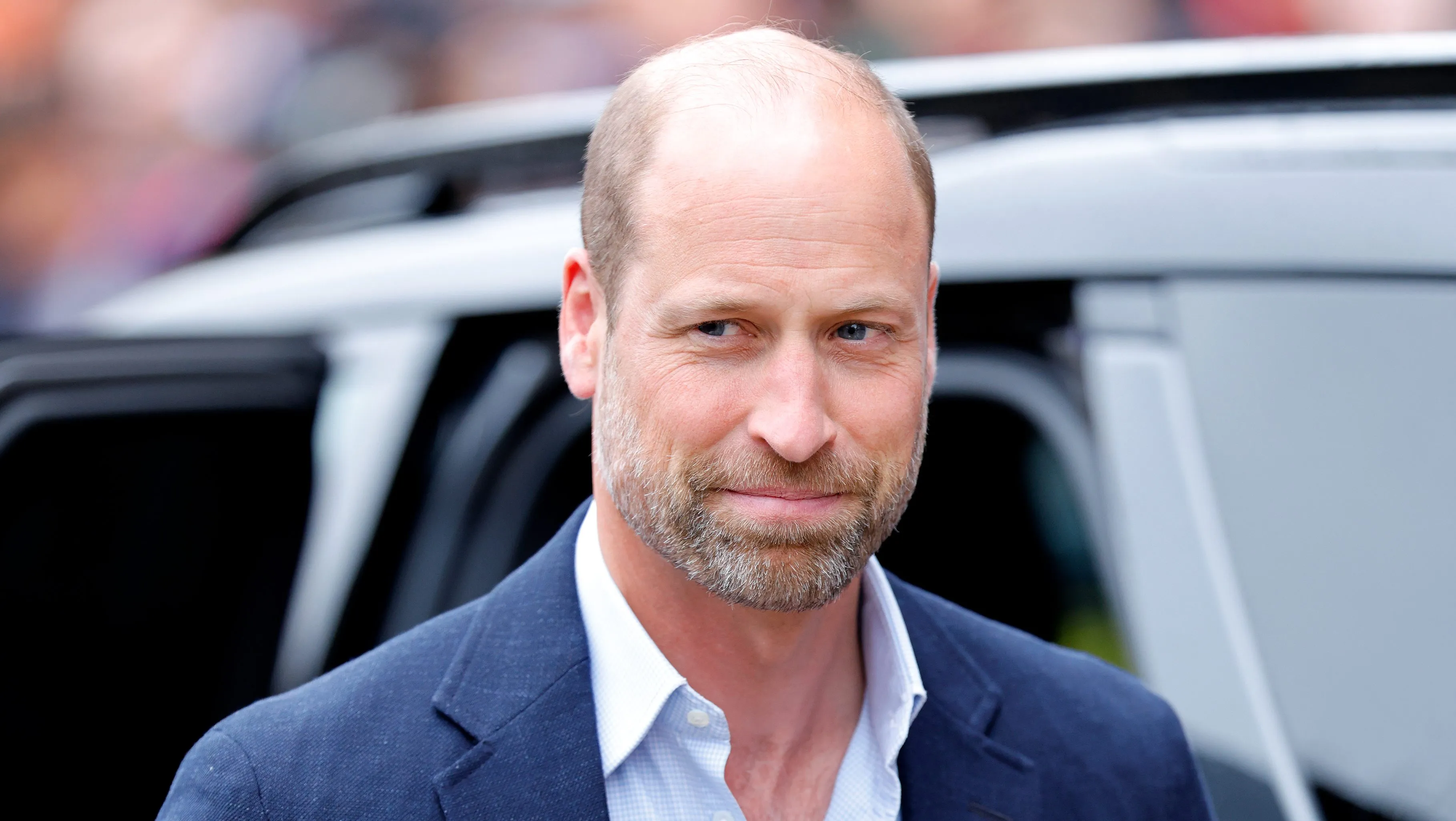 Prince William attending an official royal engagement in a dark suit.