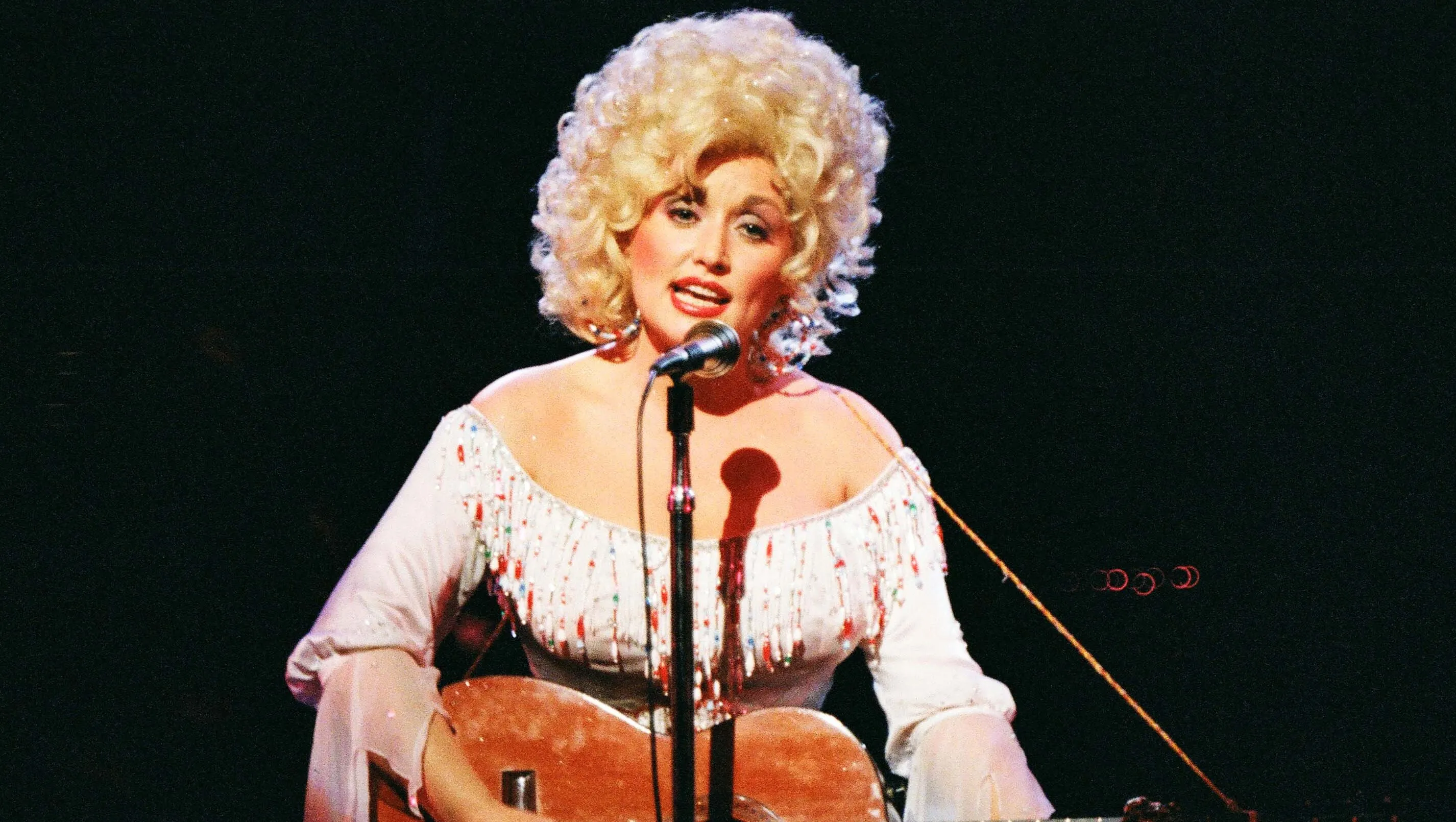 Country icon Dolly Parton making a public appearance surrounded by her security detail.