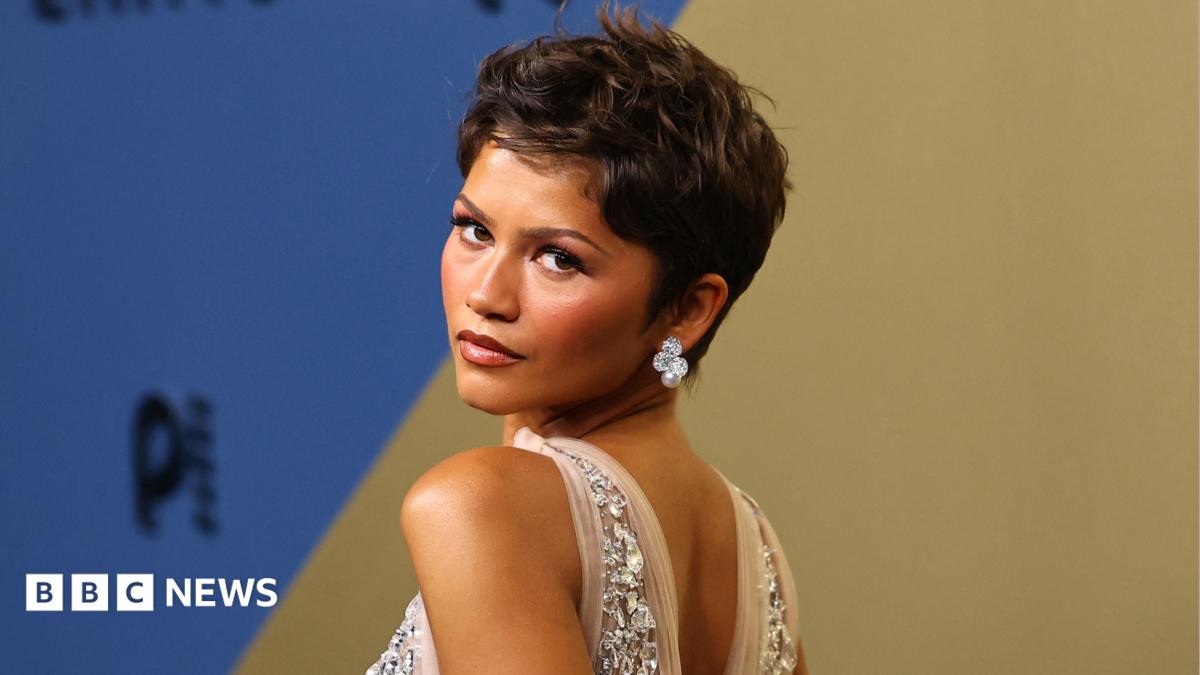 Zendaya in a jewelled dress looking behind her