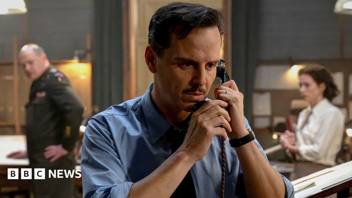 Andrew Scott in a wartime shirt with a small moustache and clipped, short hair - he is on the phone on the set of the film, looking tense