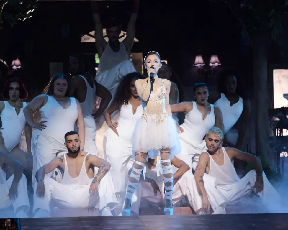 Ariana Grande at the Oakland Arena on June 6 in California. She is dressed in a white lace dress, surrounded by dancers in plain white costumes