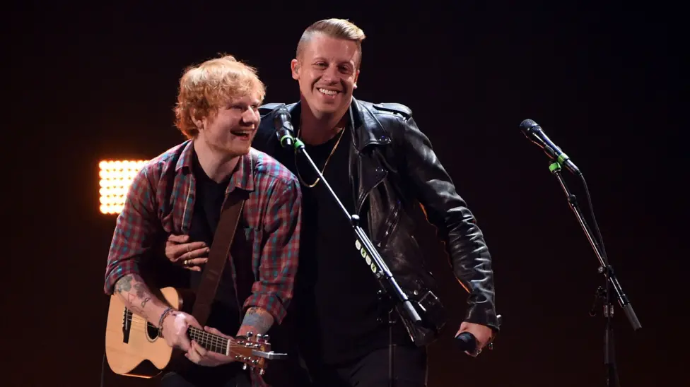 Singer/songwriter Ed Sheeran (L) and rapper Macklemore perform during the 2014 iHeartRadio Music Festival at the MGM Grand Garden Arena on September 20, 2014 in Las Vegas, Nevada. Sheeran is wearing a checked shirt and h