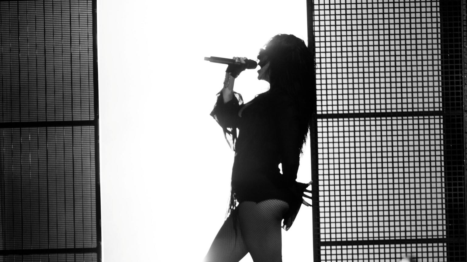 Charli XCX performing live on stage at a festival