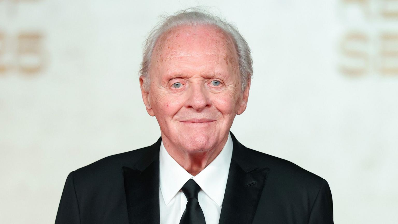 Anthony Hopkins smiling on a red carpet