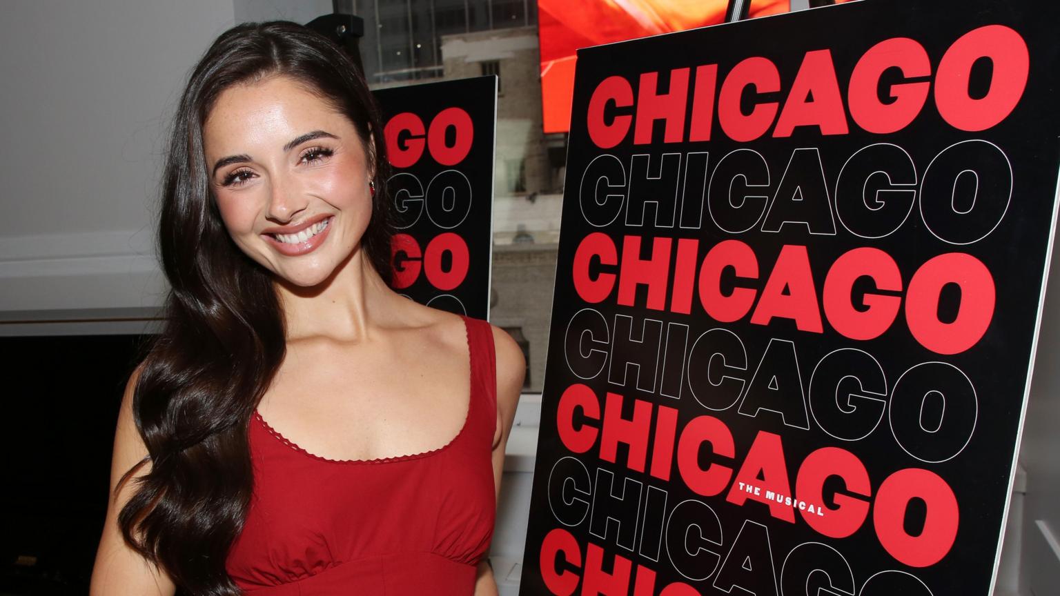 A performer dancing under warm spotlighting on a Broadway theater stage