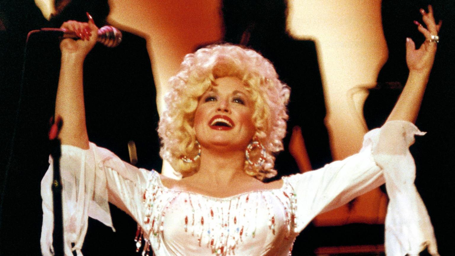 Dolly Parton performing on stage in a glittering outfit