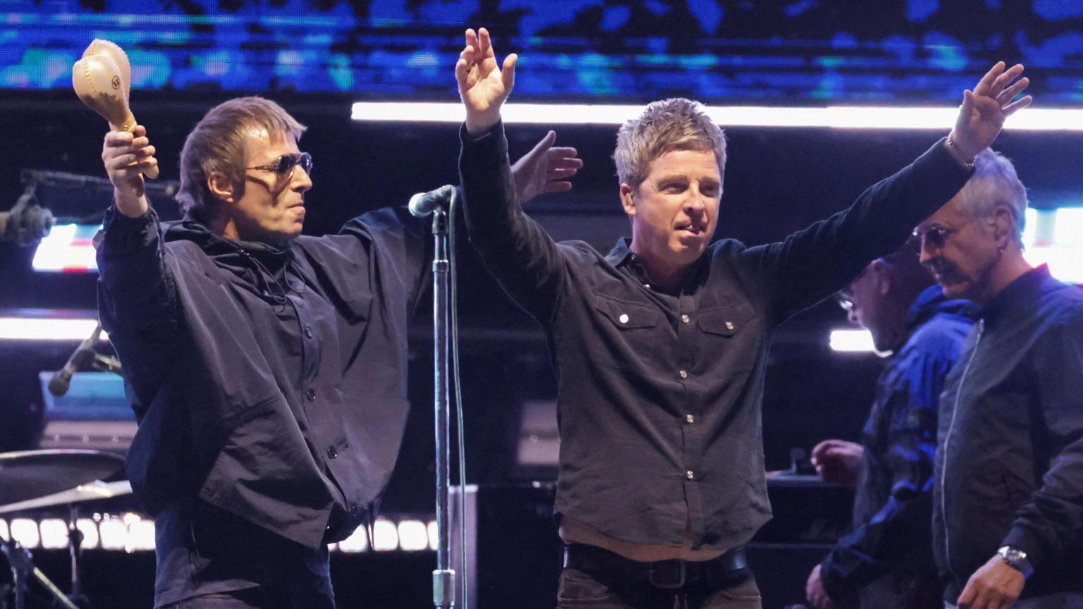 Liam Gallagher and Noel Gallagher of Oasis performing on stage